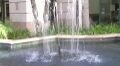 The fountain. Optical illusion of man in black suit behind the fountain caused by the architectural structure partially obscured by the water spray